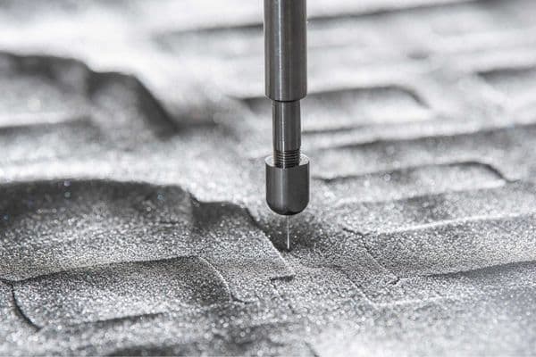 A waterjet cutting nozzle accurately cutting out gaskets from a sheet foam material in an Avon Group factory