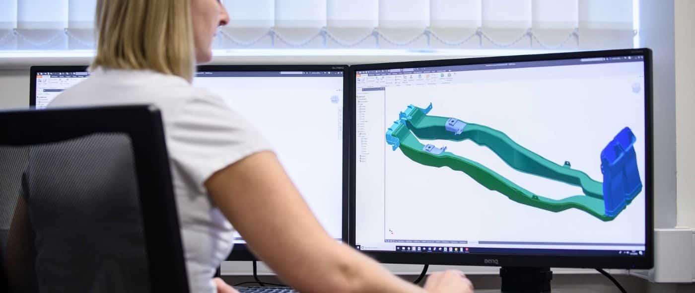 A woman runs a CAD program designing a part to be made at AER Stafford
