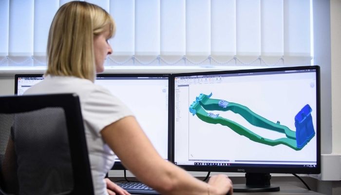 A woman designs a part on a CAD machine that will be manufactured by Avon Group